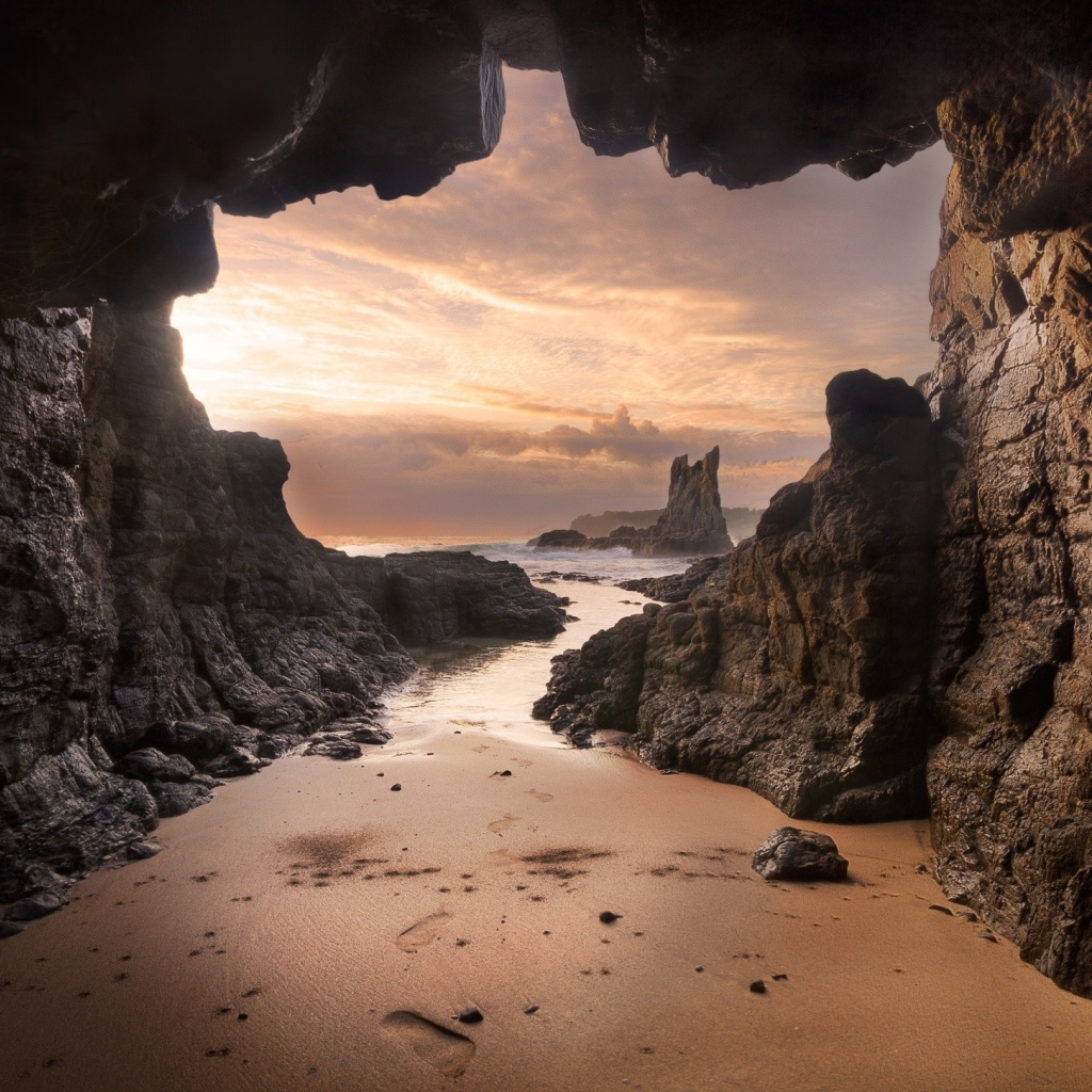 Мокрый песок у входа в пещеру