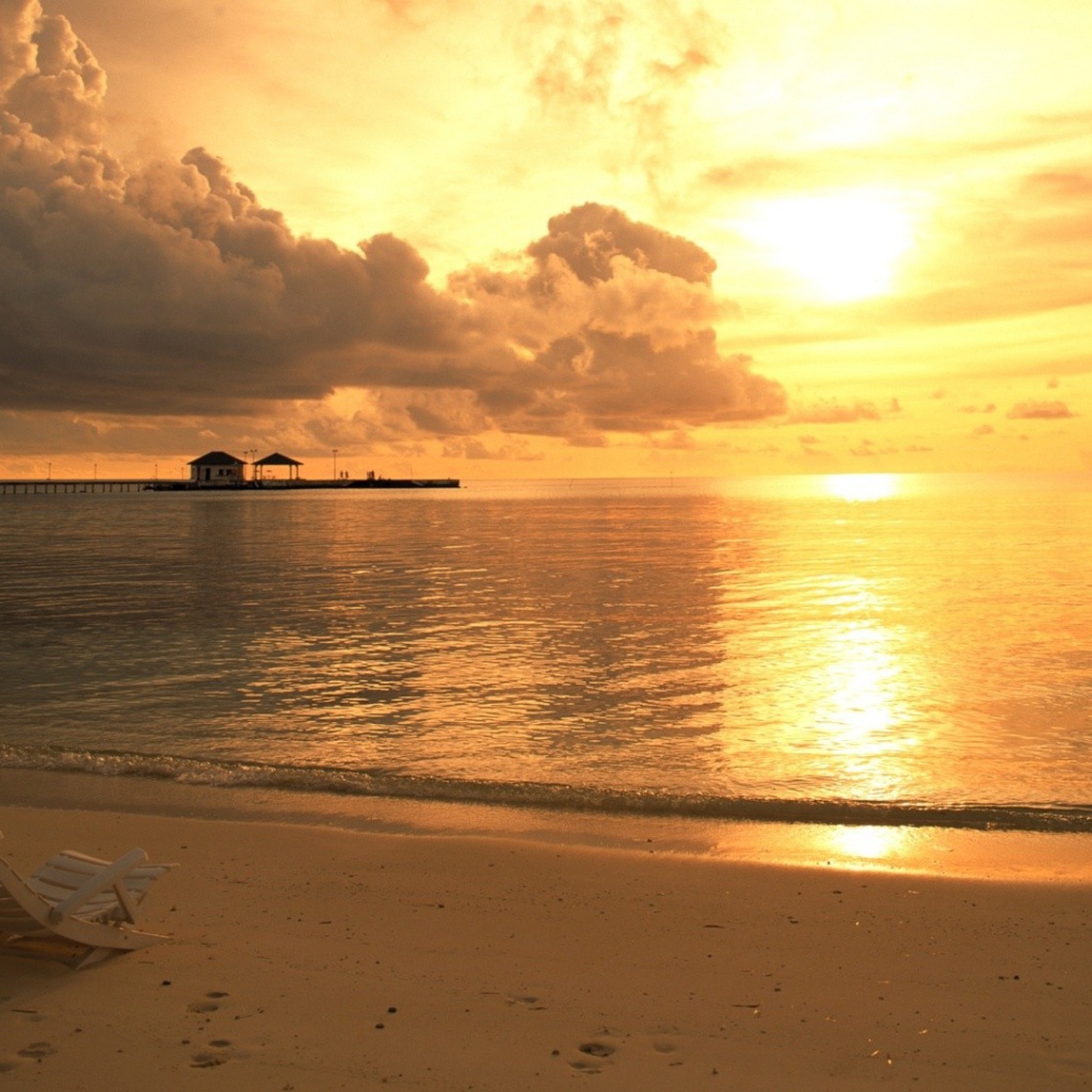 Одинокий шезлонг на пляже на закате