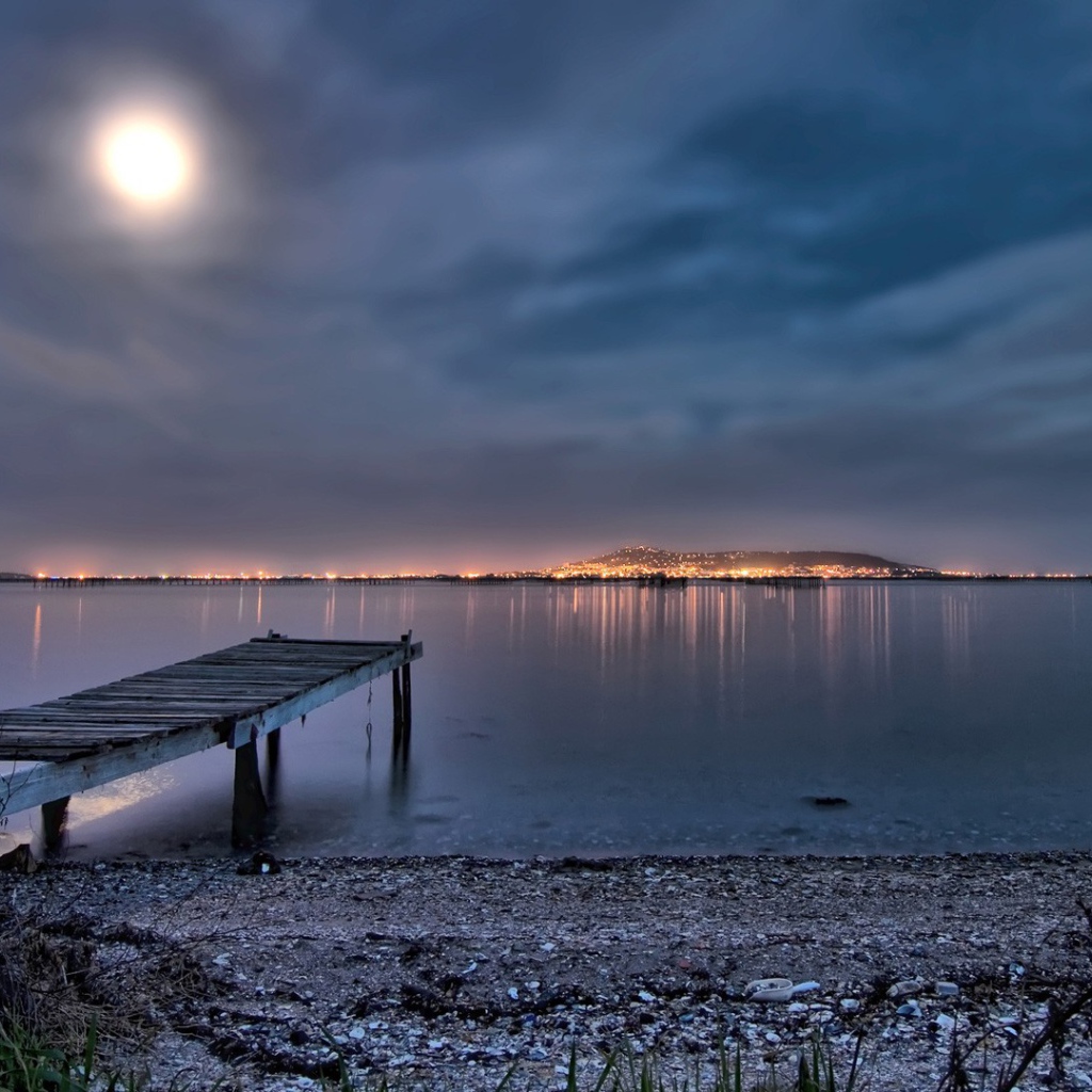 Луна над ночным пляжем с видом на город