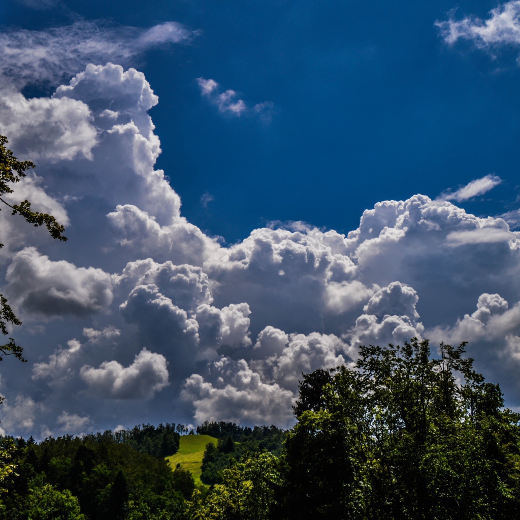 Кучевые облака над зелеными холмами
