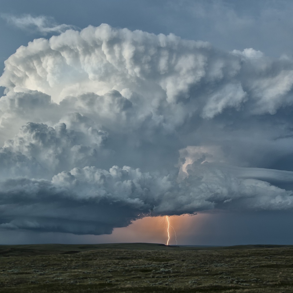 Оранжевая молния в огромном белом облаке