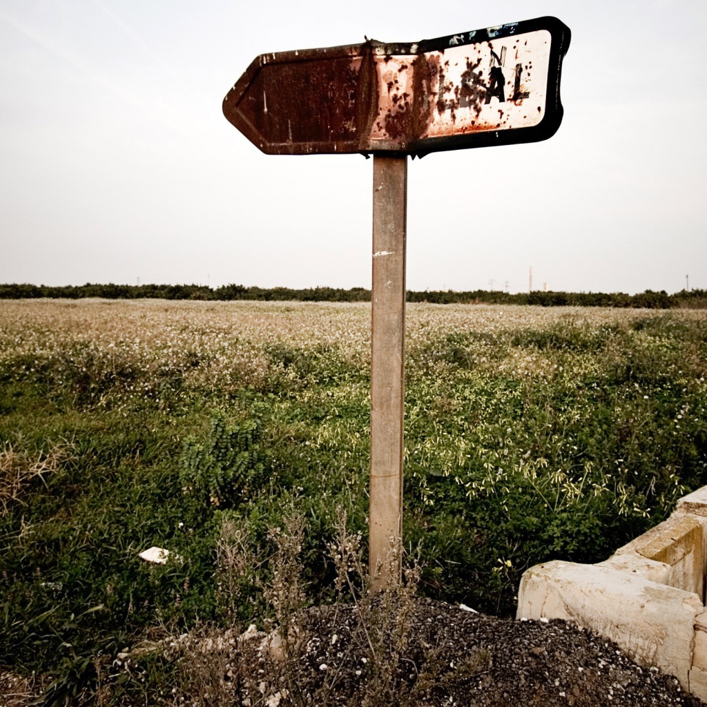 Ржавый указатель направления у поля