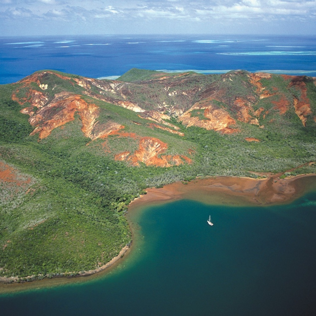 Белая лодка у необитаемого лесистого острова