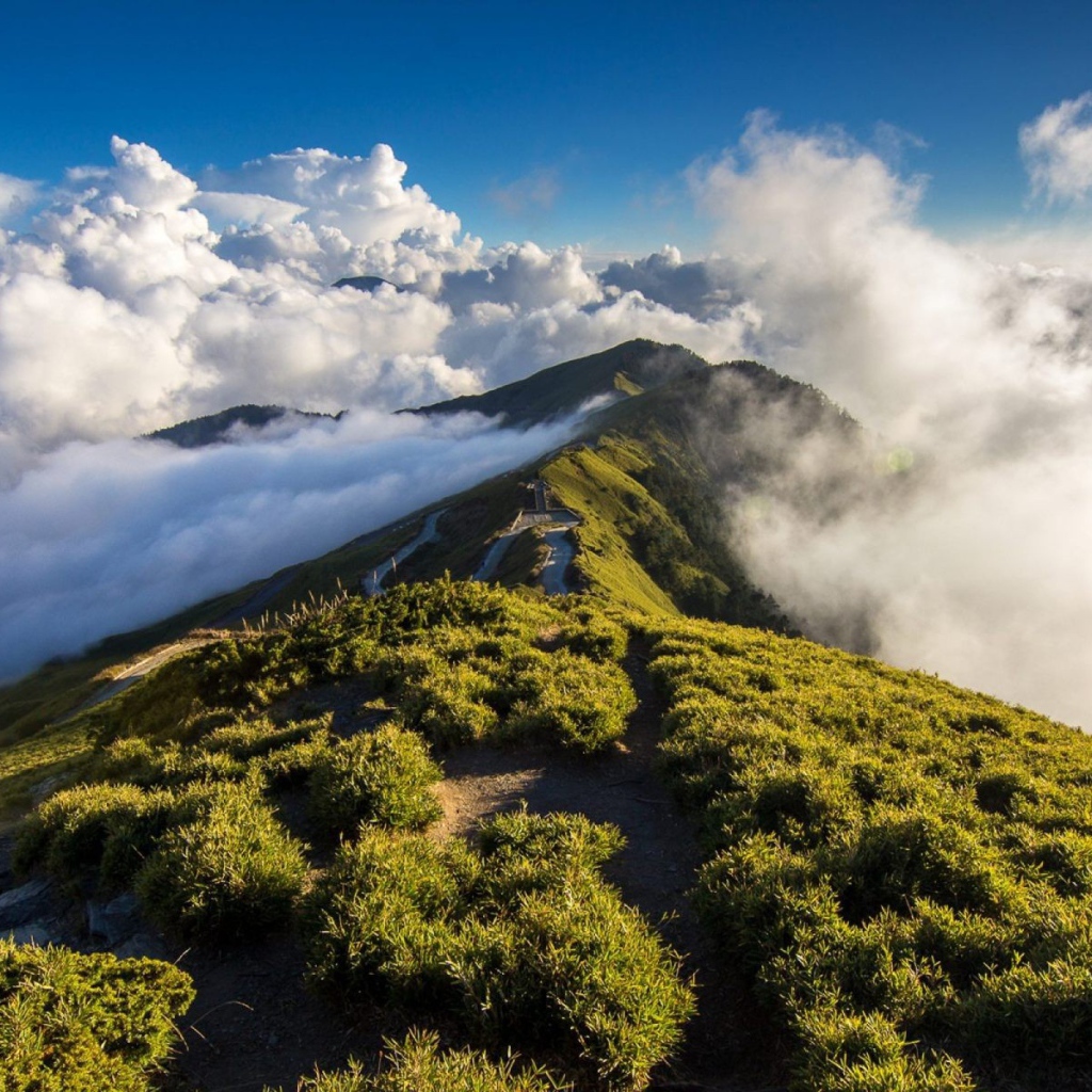 Зеленый горный хребет среди облаков