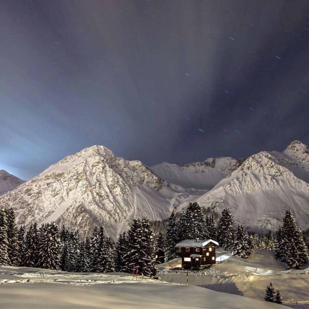 Лучи света над заснеженными горами