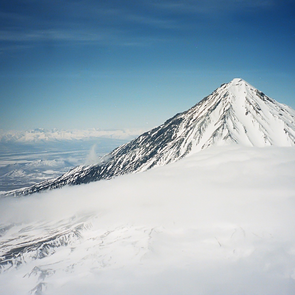 Вершина покрытой снегом горы в облаке