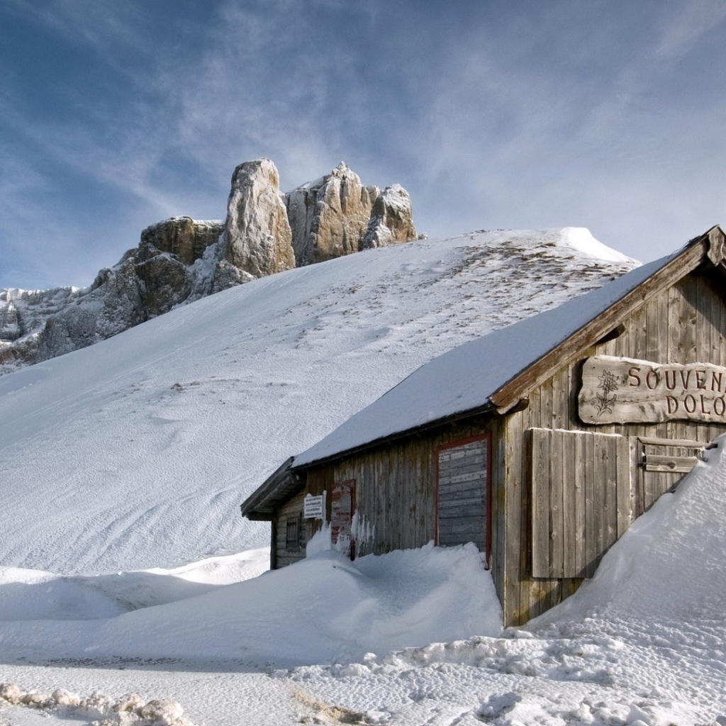 Деревянный домик замело снегом в горах