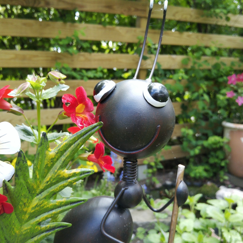 Фигурка муравья в саду