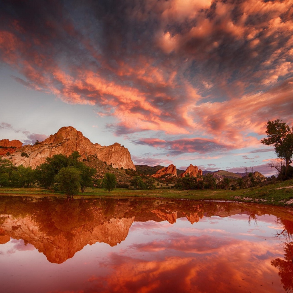 Облака отражаются в коричневой воде озера