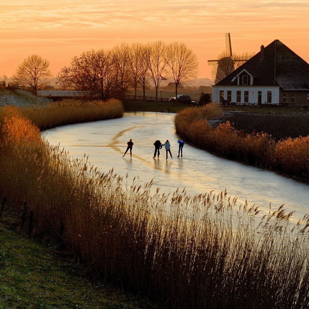 Дети катаются на коньках по замерзшей реке в Нидерландах