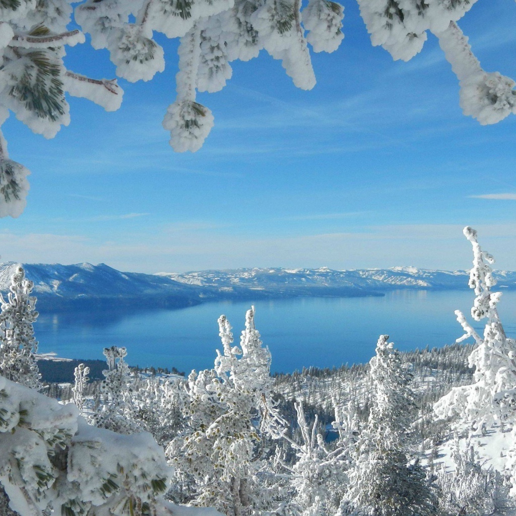 Горное озеро в рамке из заснеженных ветвей