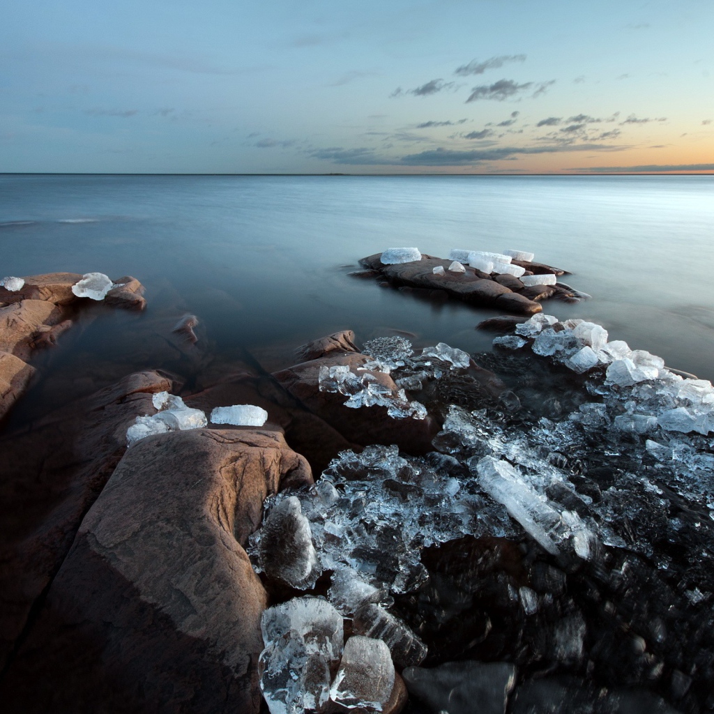 Куски льда на камнях у берега