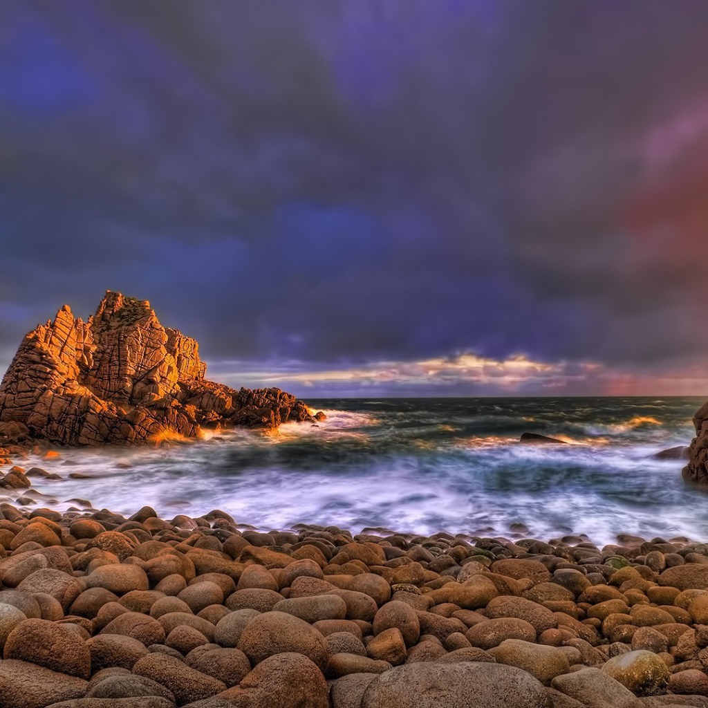 Большие гладкие камни на берегу бурного моря