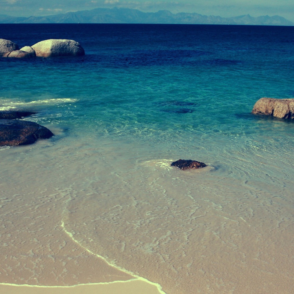 Камни в синей воде у берега моря