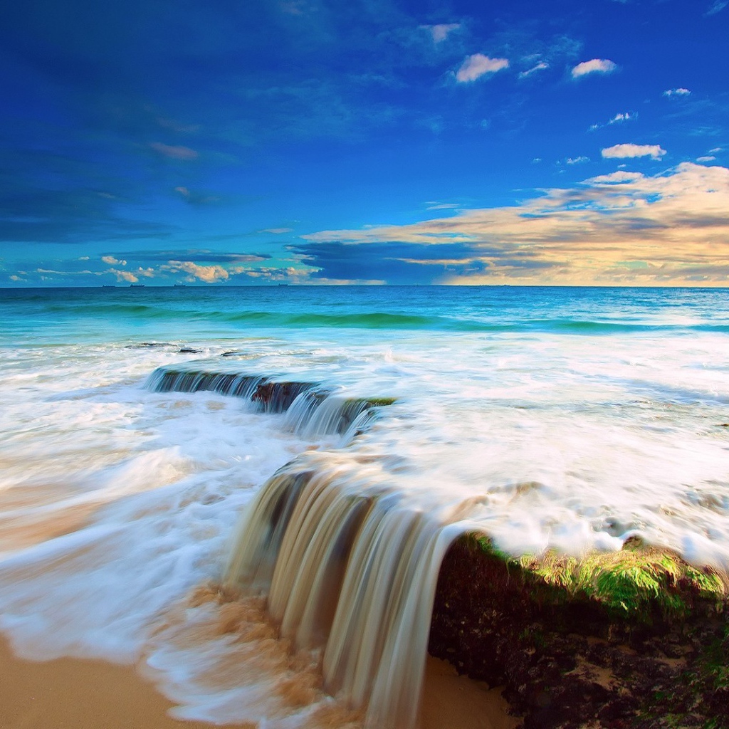 Волна прибоя накатывает на прибрежные камни