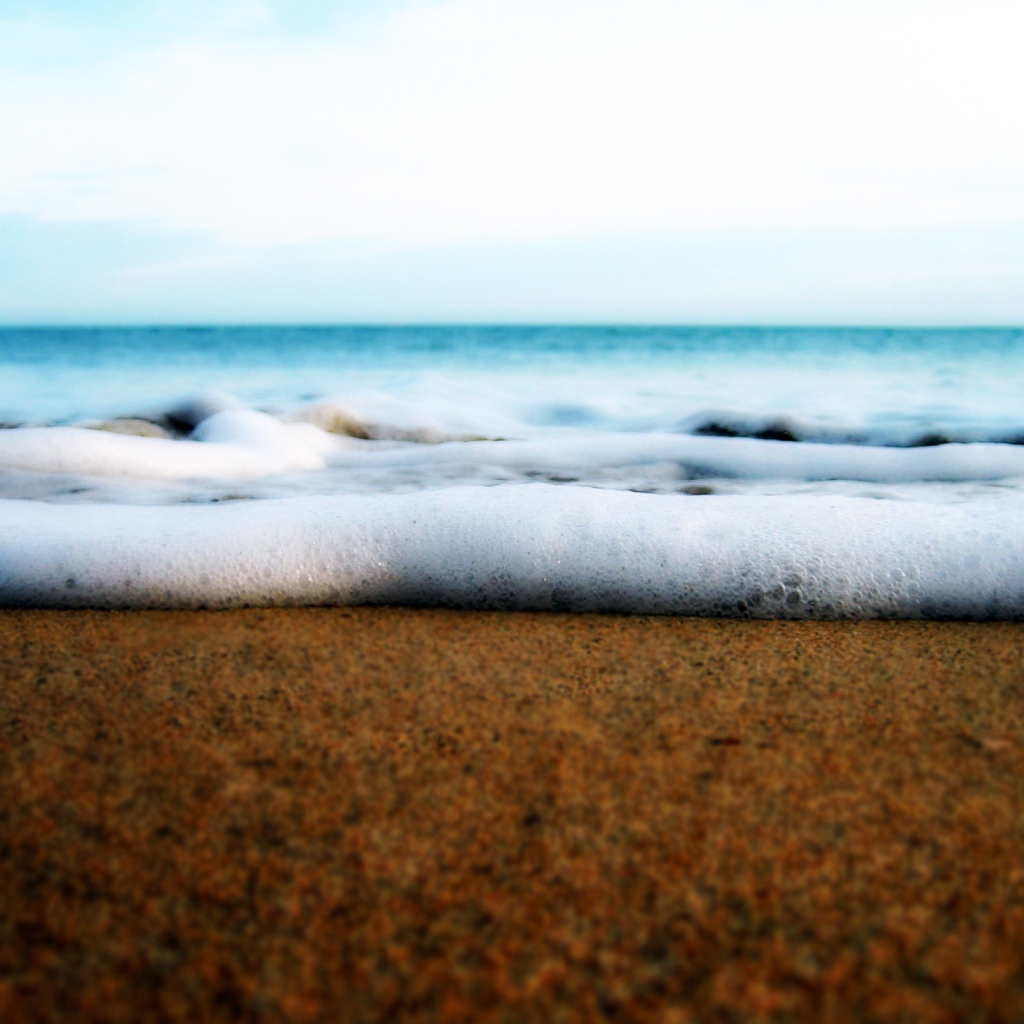 Белая пена волны у берега