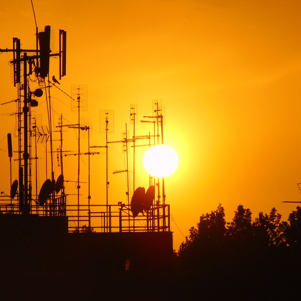 Вышки связи на фоне солнца