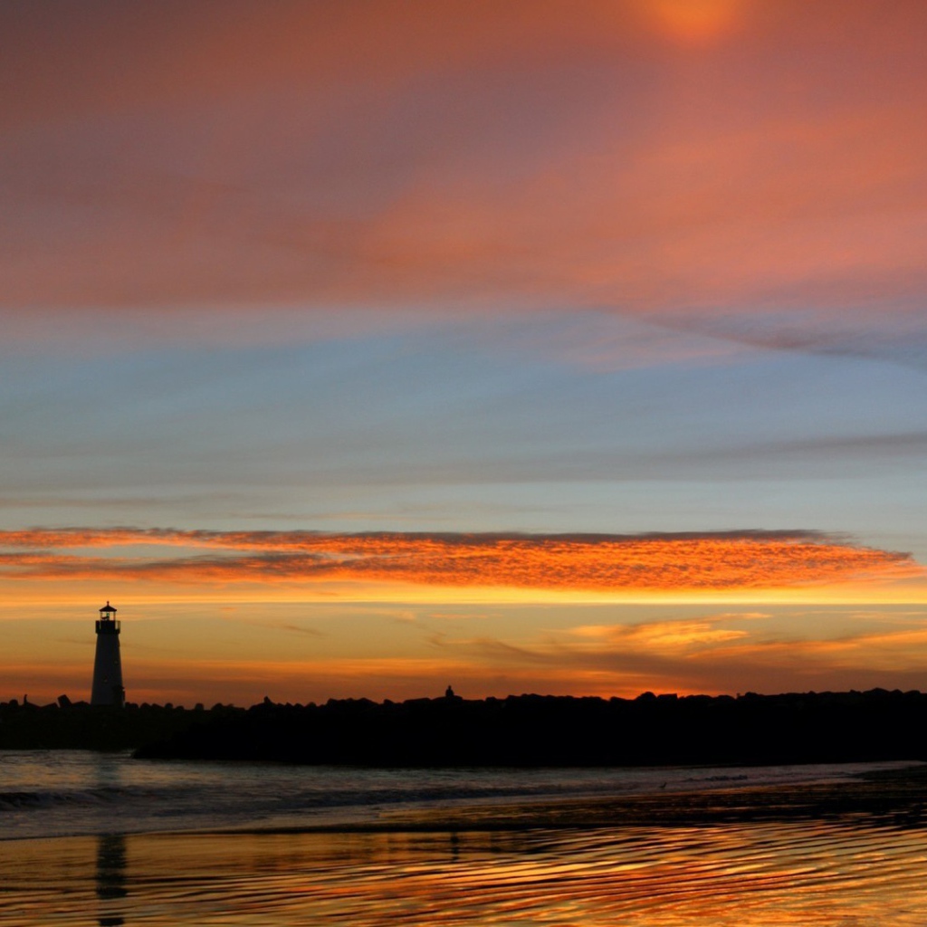 Силуэт маяка на фоне оранжевых облаков