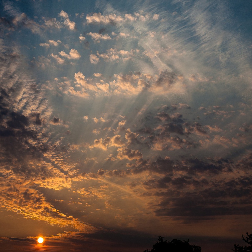 Солнце на закате освещает перистые облака