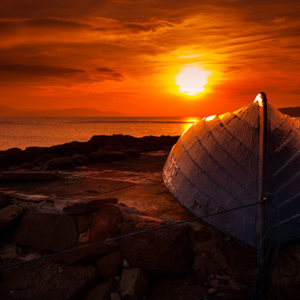 Перевернутая лодка на фоне заката