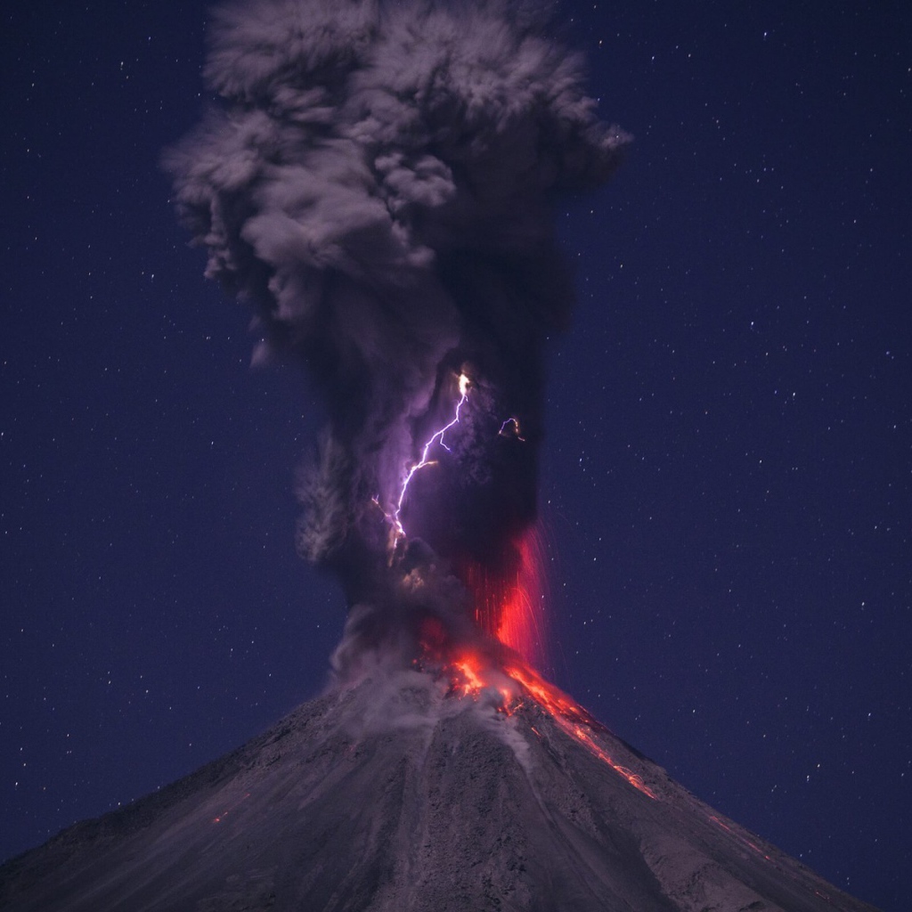 Выброс пепла из вулкана на фоне звездного неба