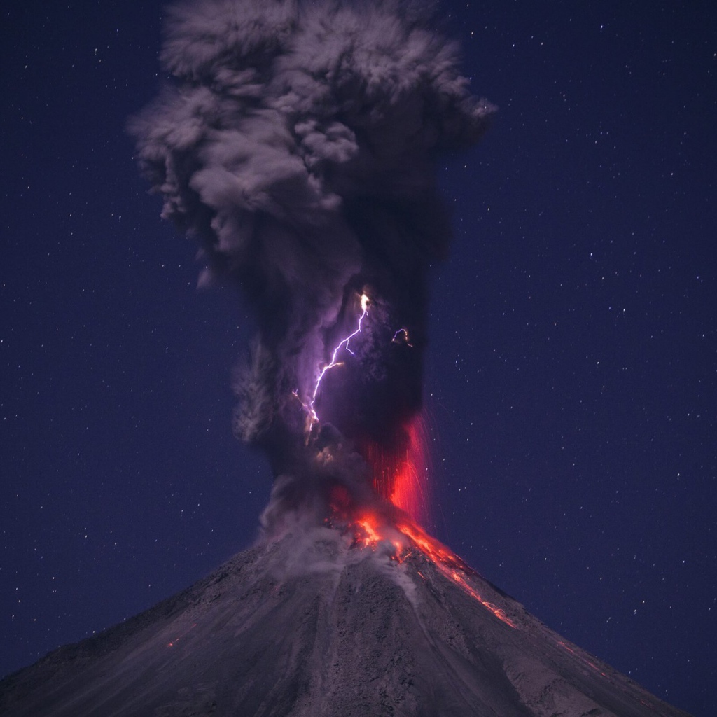 Выброс пепла из вулкана на фоне звездного неба