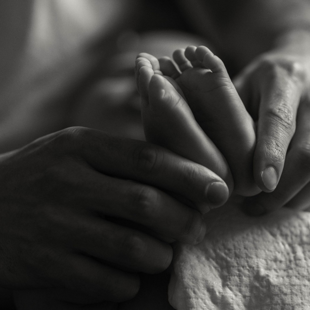Ступни ребенка в руках отца
