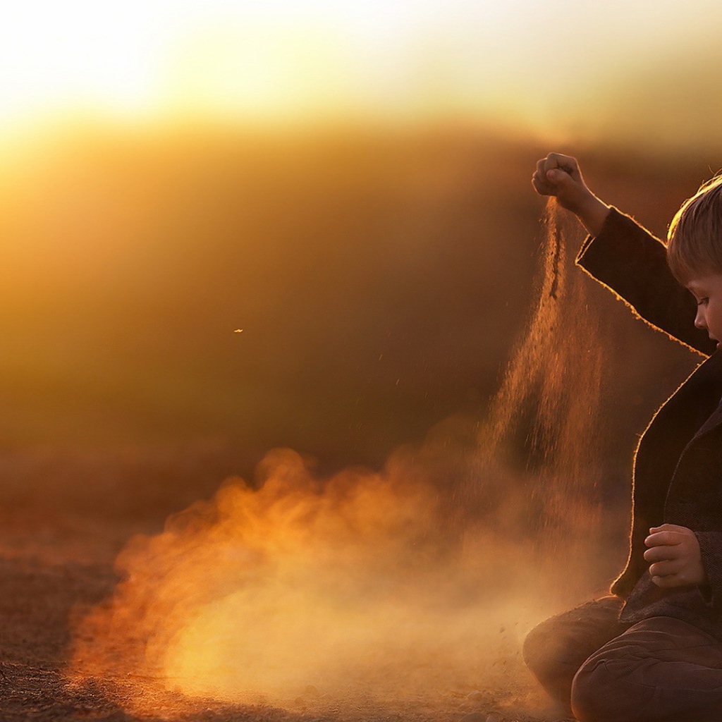 Мальчик играет песком