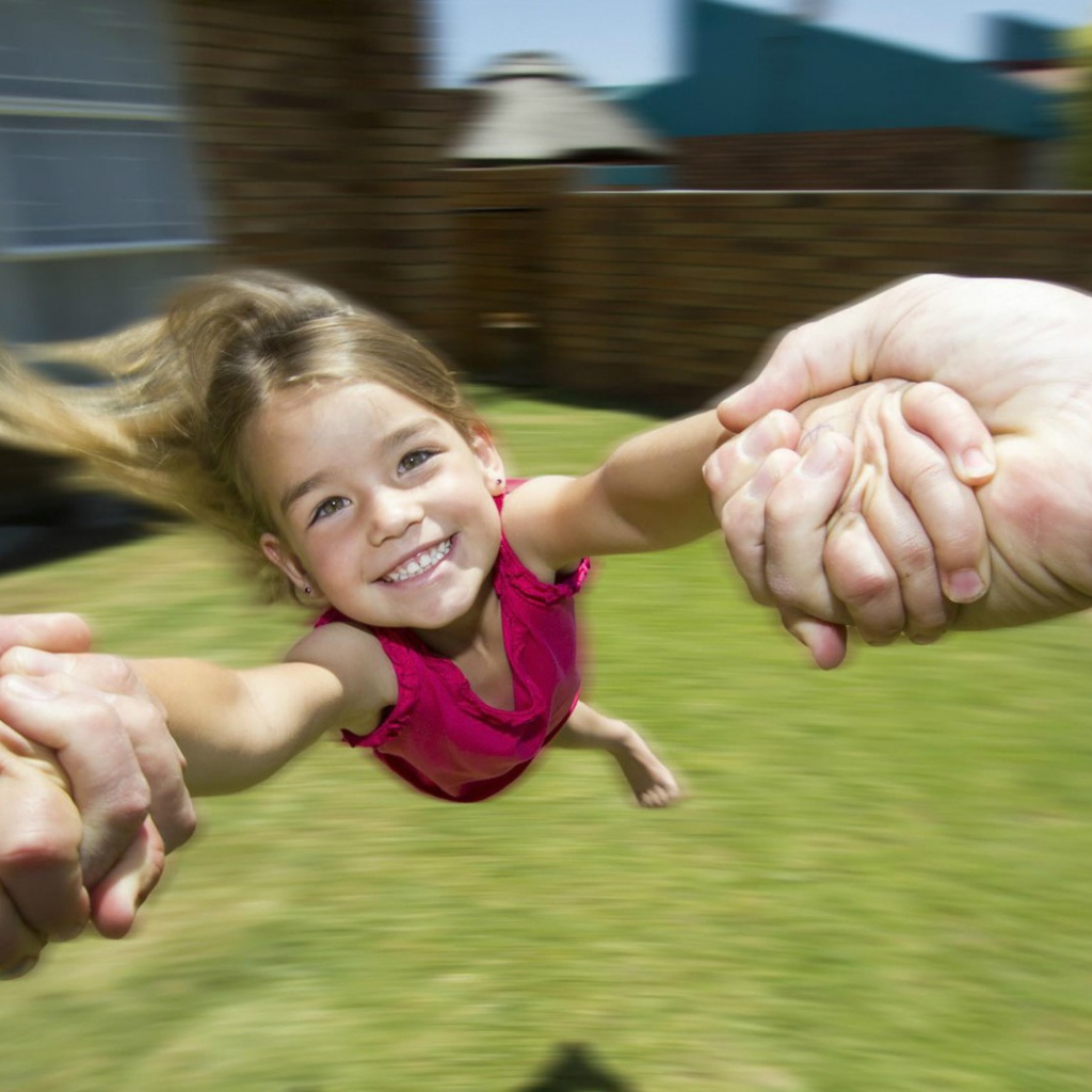 Веселая девочка в руках отца