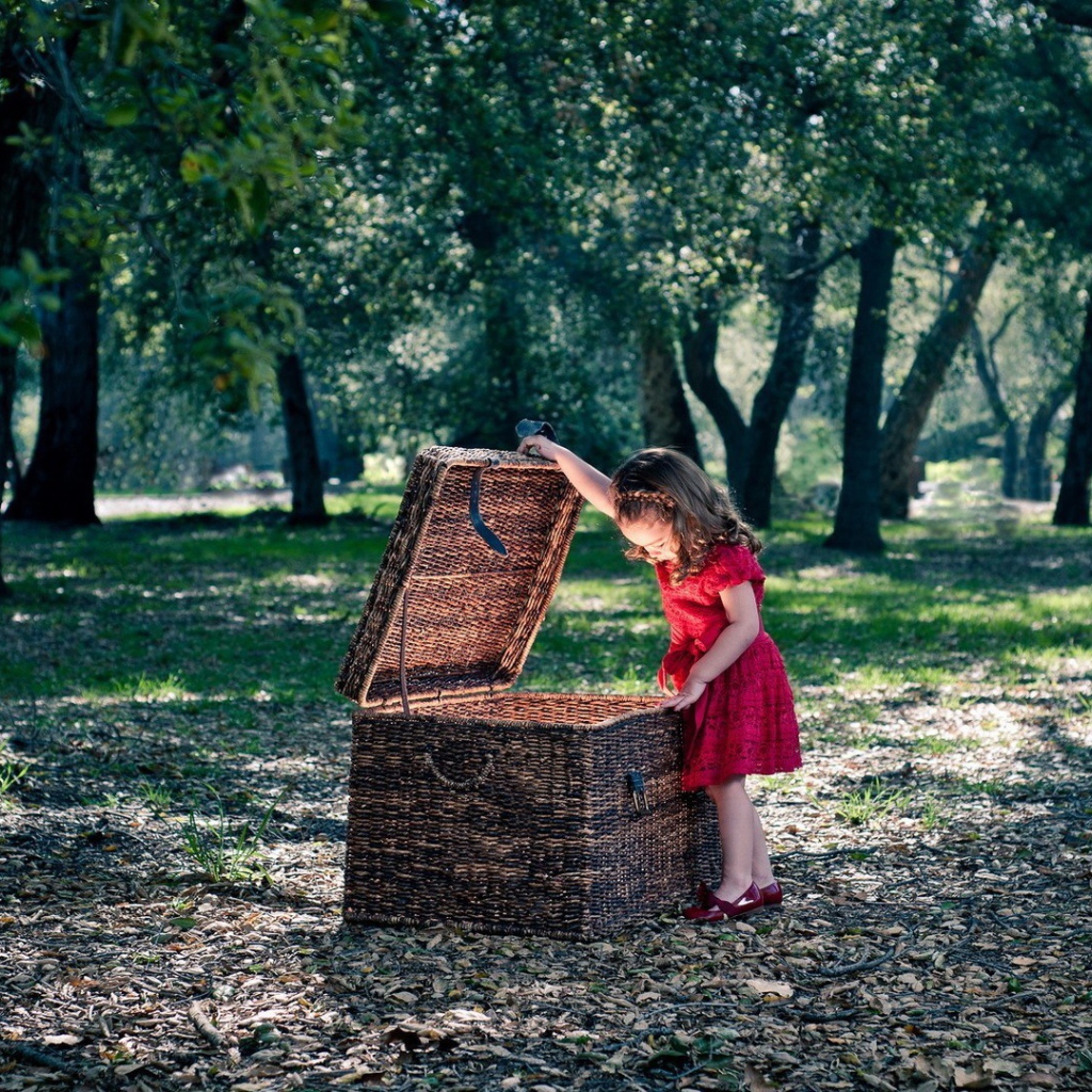 Девочка заглядывает в плетеную корзину
