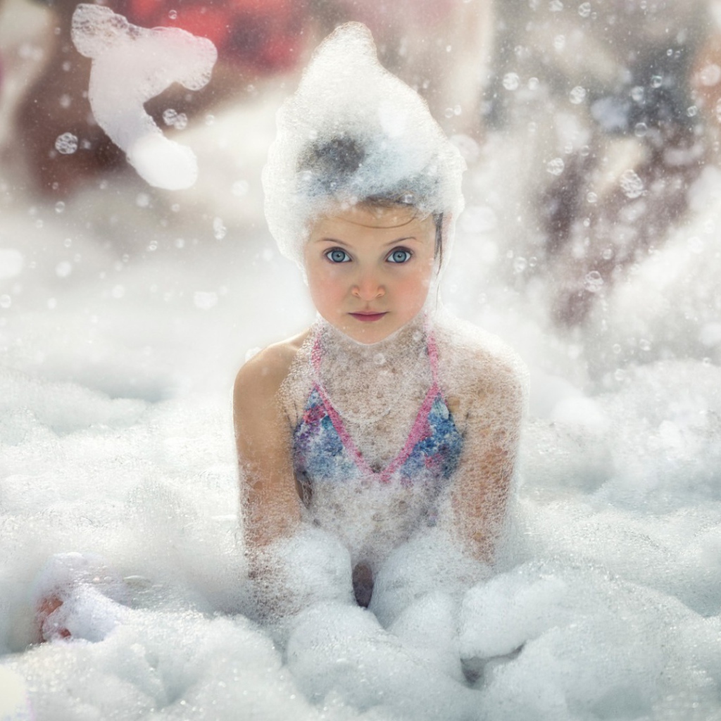 Девочка играет в пене