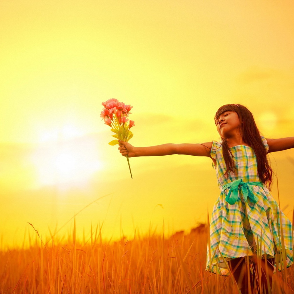 Девочка с букетом стоит в поле