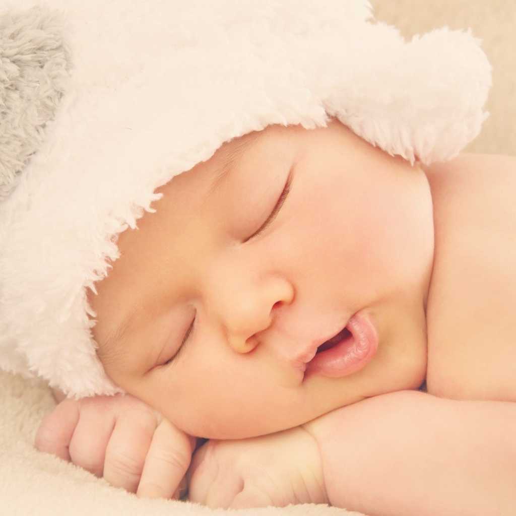 Спящий ребенок в белой шапке