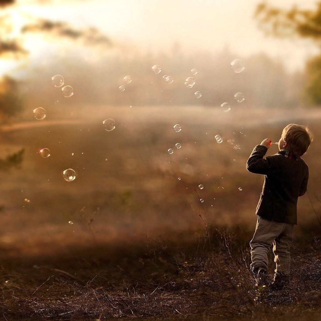 Мальчик запускает мыльные пузыри