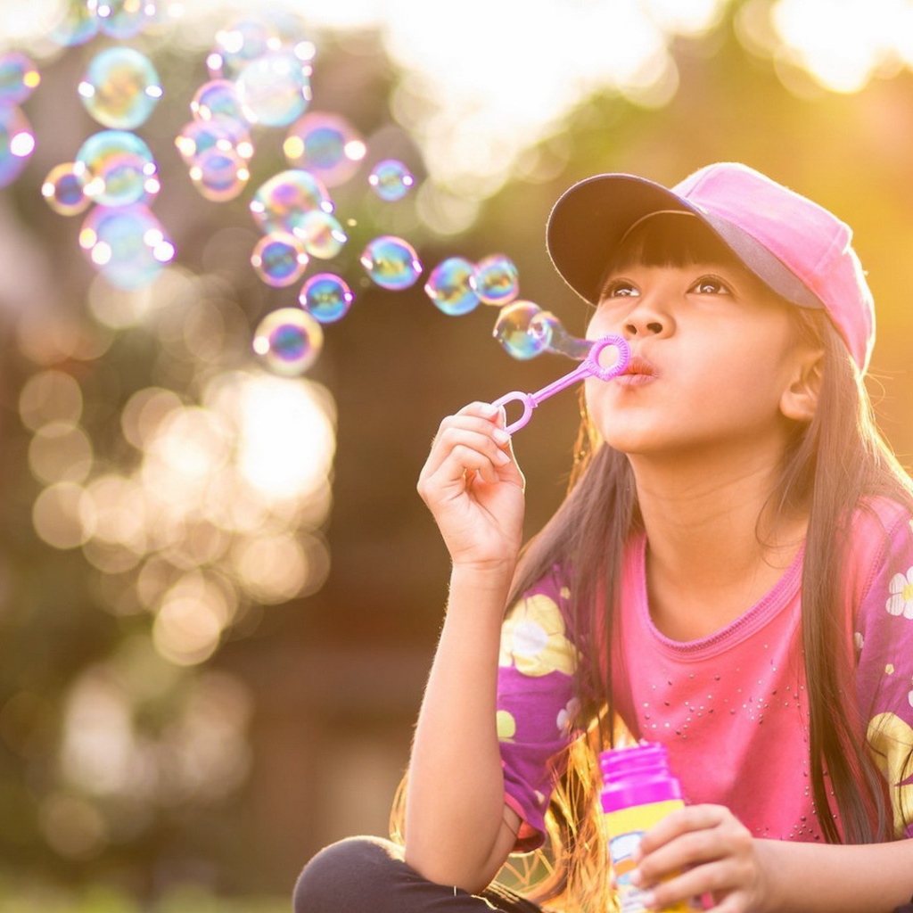 Девочка запускает мыльные пузыри