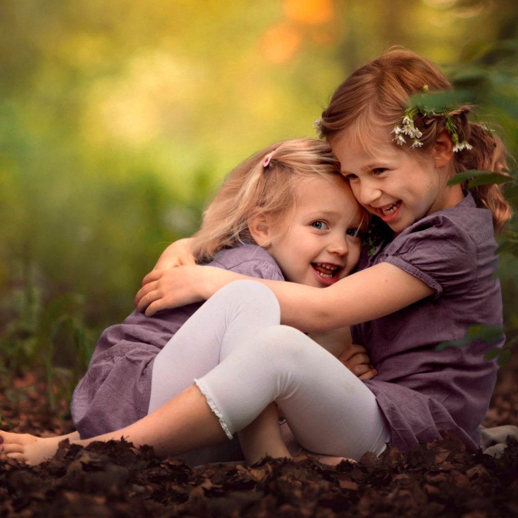Две милых сестрички играют в парке