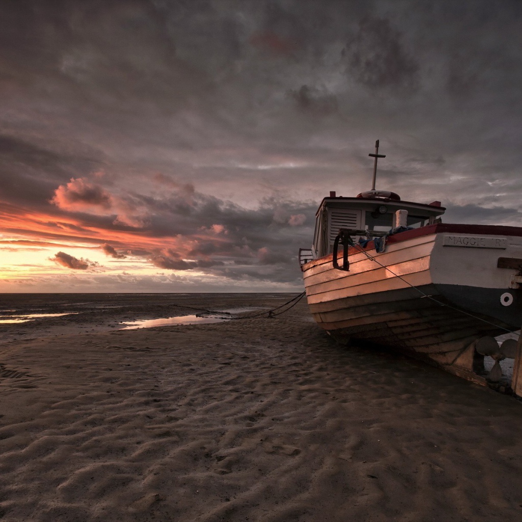 Лодка на песке пляжа во время отлива