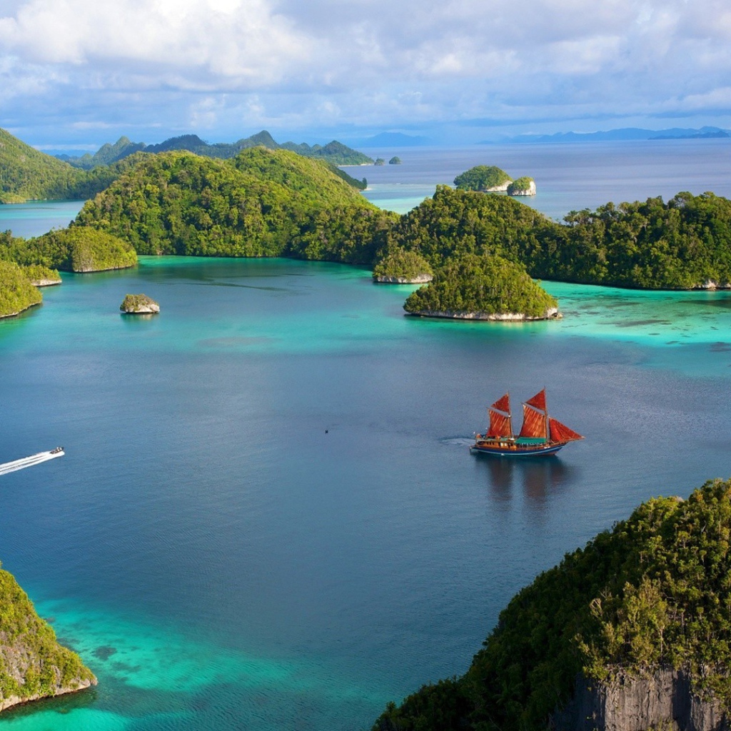 Корабль с красными парусами среди островов