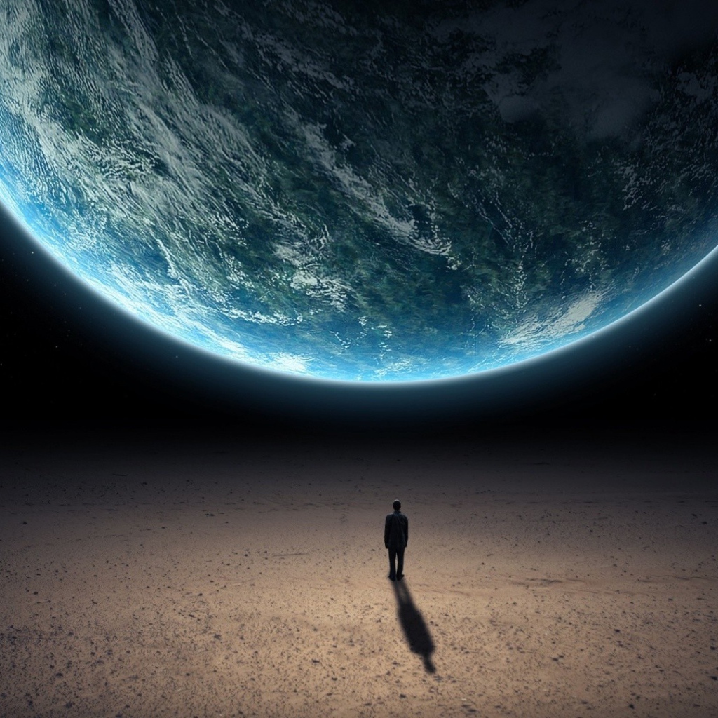 Человек стоит перед планетой