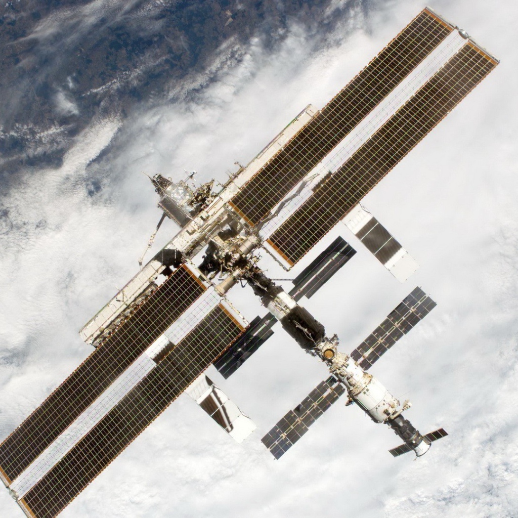 МКС пролетает над облаками на Земле