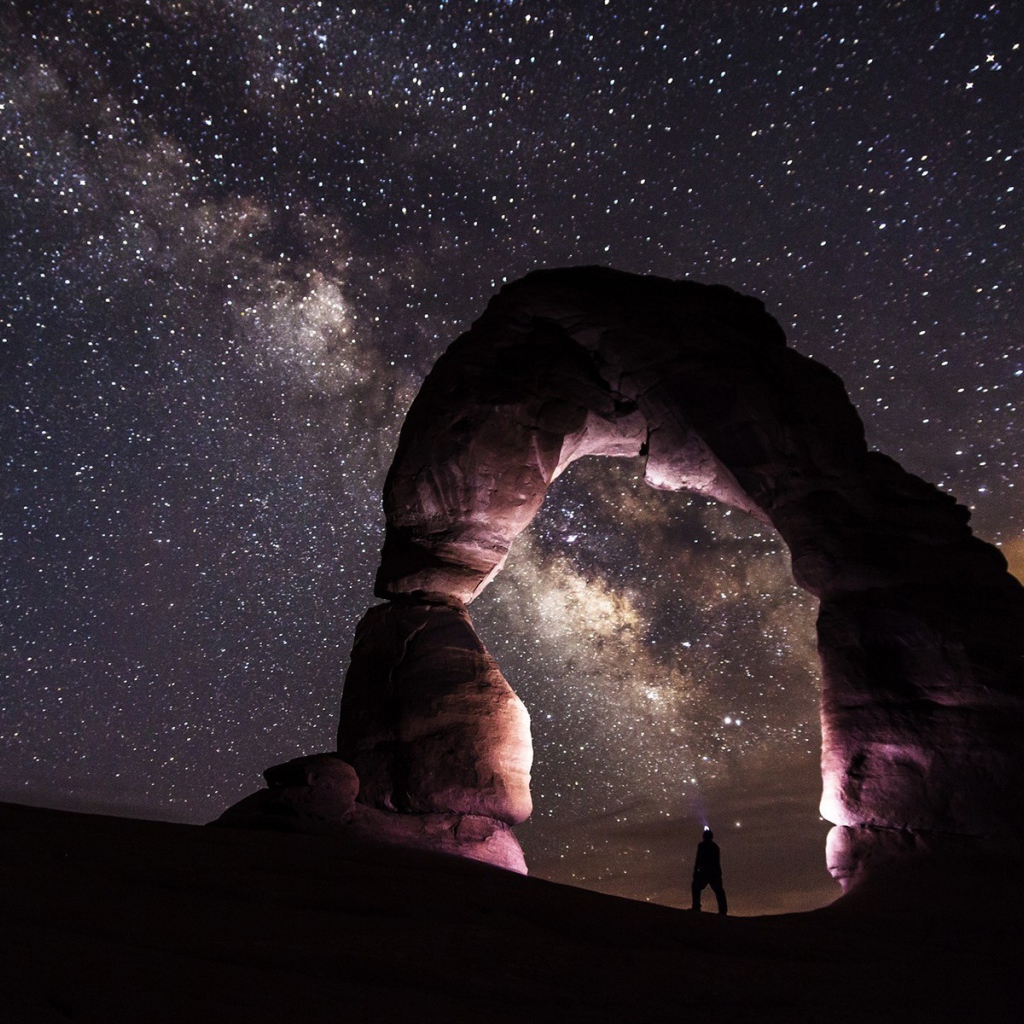 Природная каменная арка на фоне звезд