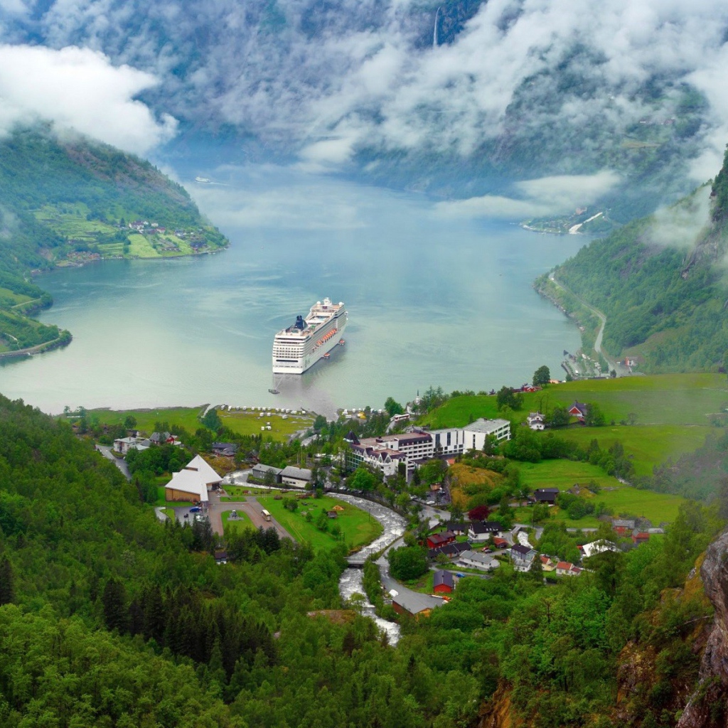 Круизный корабль у прибрежной деревушки в Норвегии
