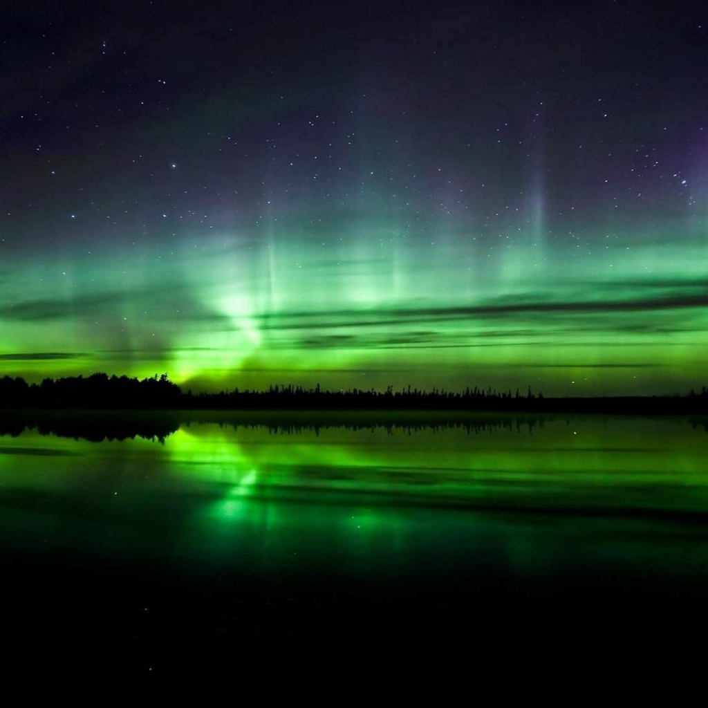 Северное сияние над водой в Норвегии
