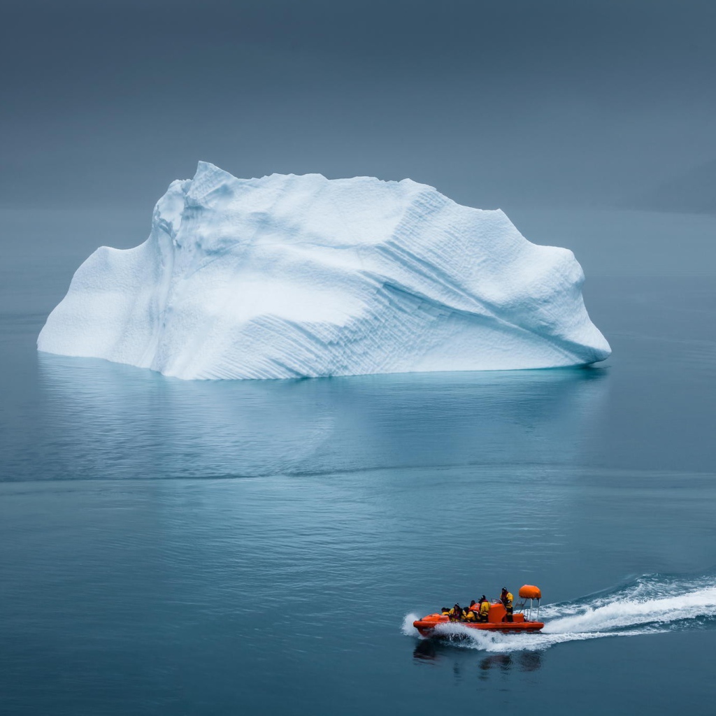 Моторная лодка у айсберга в Арктике