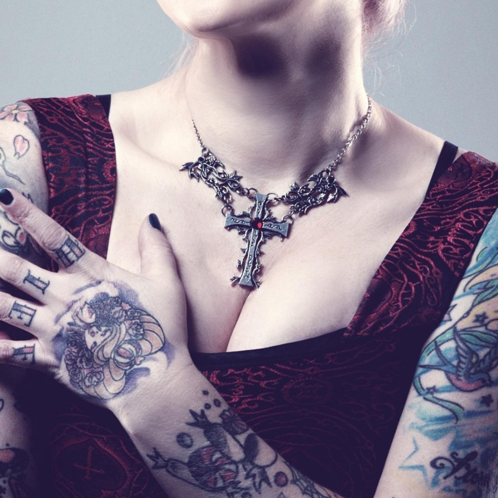 Красивый кулон на груди татуированной девушки