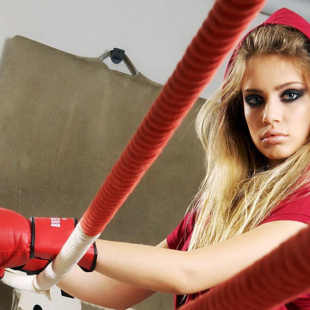 Блондинка в перчатках на боксерском ринге