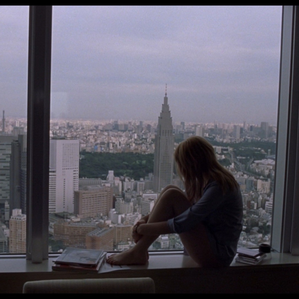 Девушка Скарлетт Йоханссон смотрит на город в окно