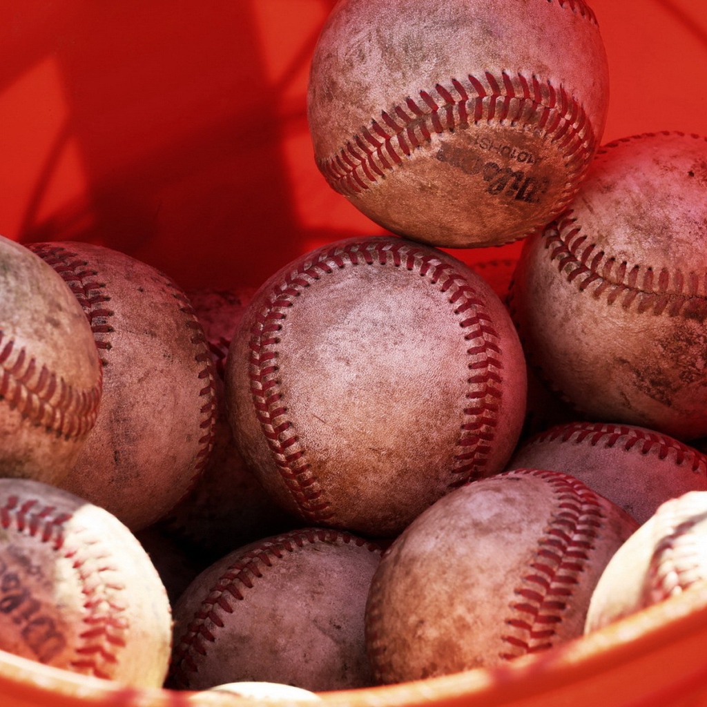 Красное ведро с мячами для бейсбола
