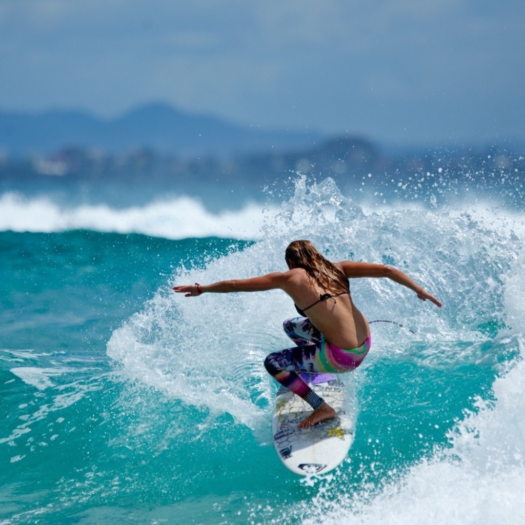 Девушка серфер оседлала голубую волну