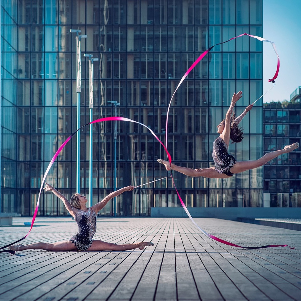 Гимнастки с лентами на площади перед небоскребом